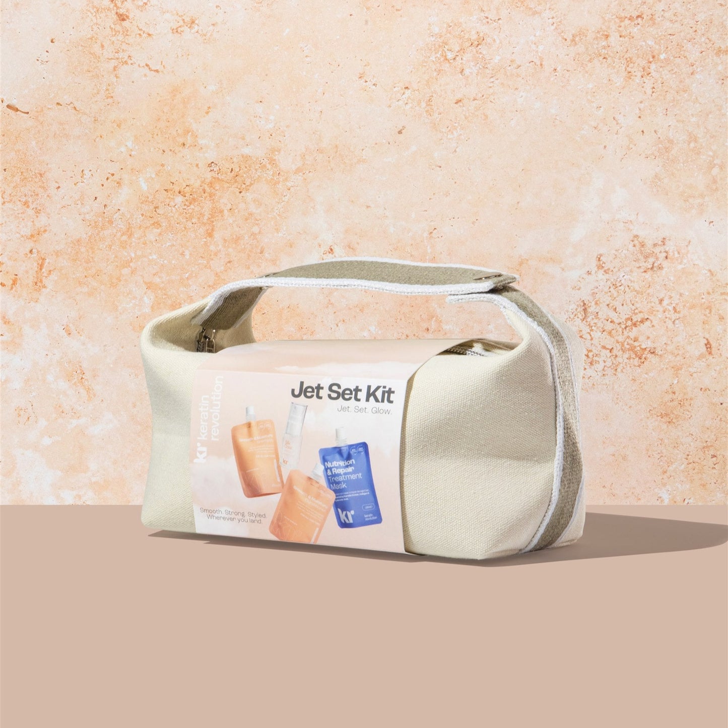 Cosmetic bag labeled 'Jet Set Kit' on a beige background
