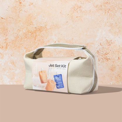 Cosmetic bag labeled 'Jet Set Kit' on a beige background
