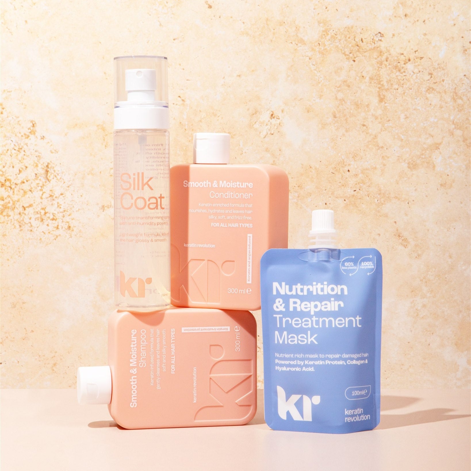 Set of hair care products including bottles and a mask on a textured beige background