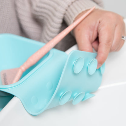 Light blue silicone shoe insert being adjusted by a person with a neutral background
